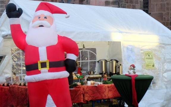 Stand auf dem Weihnachtsmarkt mit Stehtisch und aufgepusteter Nikolaus-Figur